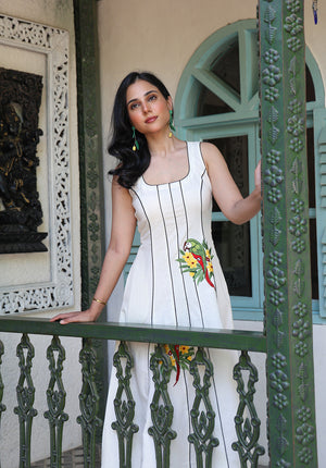 Model wearing Parasio dress in ivory with parrot embroidery and black piping details