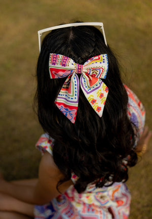 Step into a storybook with this bow! Featuring Alice-inspired motifs and vibrant colors, this whimsical hair clip adds charm to any outfit. Ships in 2–4 days.