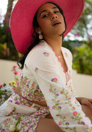Close-up of sleeveless top with floral embroidery and pink hat — chic and summer