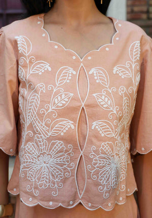 Close-up of neckline and white floral embroidery on fawn coord top