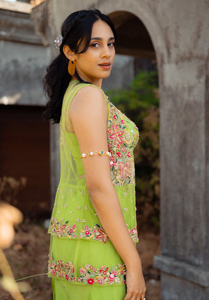 Side view of the model in green sharara set showing floral embroidery and layered detail on the jacket.