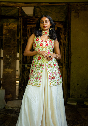 Model wearing full ivory sharara set with kurti, sharara, and dupatta in a standing pose.