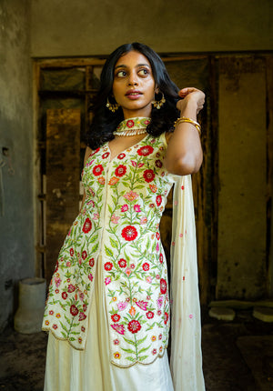 Model wearing sleeveless kurti with a center cut, styled with a matching ivory dupatta.