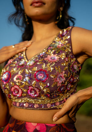 Closeup of solid-color embellished blouse with sleeveless design and V-neckline, perfect for festive events.