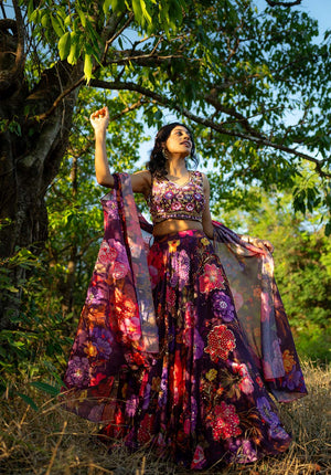 Full lehenga set with digital floral print worn by model standing near a tree, styled with matching dupatta and blouse