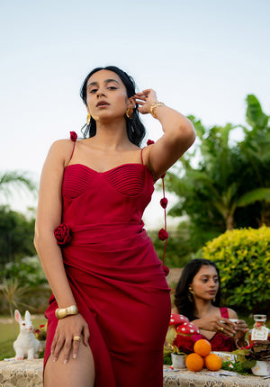 Model showcasing a red drape-style dress styled for a party, highlighting a fashionable and elegant evening look.