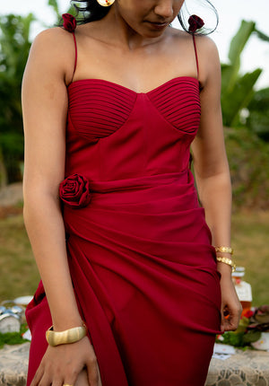 Red dress featuring a sweetheart neckline and floral detail at the waist, styled with gold bangles for a festive touch.