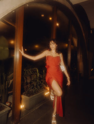 Model wearing a long red dress in a night setting, styled perfectly for an elegant and glamorous party appearance.
