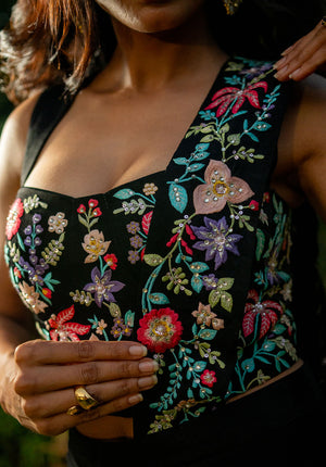 Close-up image of sweetheart neckline blouse with floral embellishments and draped saree pallu.
