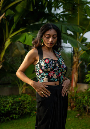 Side pose highlighting corset-style sleeveless blouse with broad straps in saree fusion set.