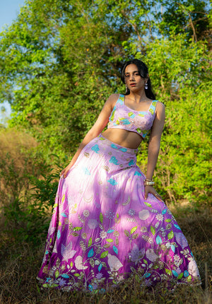 Model standing in a lehenga set with blouse and skirt, styled with golden bangles."