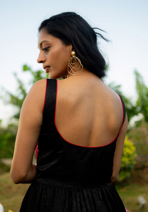 Back view of model in black and red bustier dress with deep square back cut.