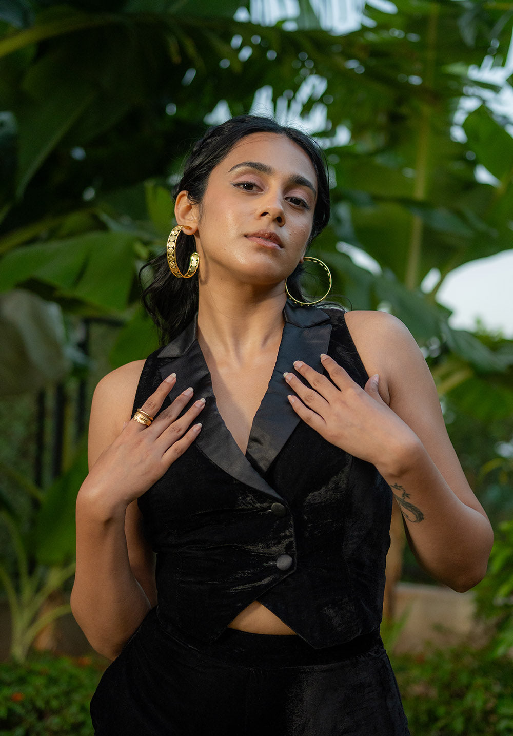 Model in sleeveless black waistcoat and wear hoops earrings