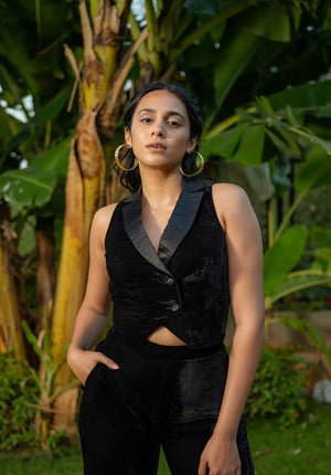 Model wearing a black waistcoat with shawl collar, posing in the garden