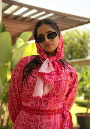 Close-up of model wearing a matching printed scarf and floral dress in coordinated colors