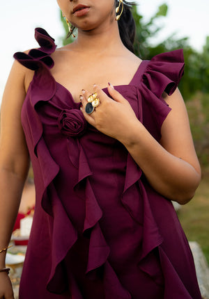 Close-up of model wearing a ruffled-strap dress accessorized with a golden ring