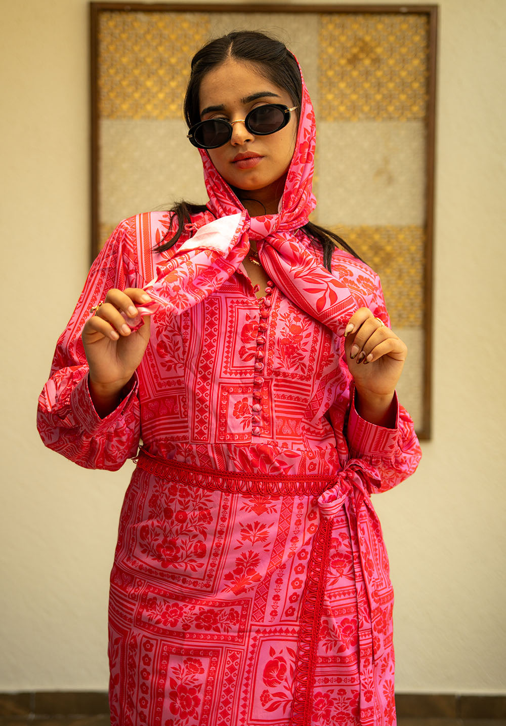 Model wearing scarf and sunglasses with a printed dress featuring potli button detailing