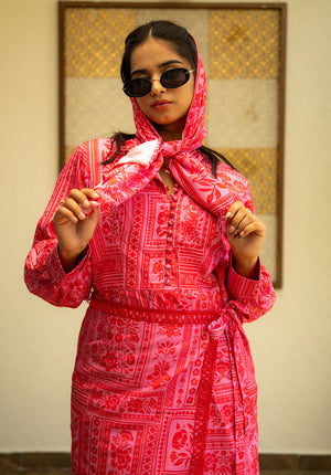 Model wearing scarf and sunglasses with a printed dress featuring potli button detailing