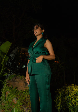 Side pose of model wearing a wrap-tie jacket in green during a night scene