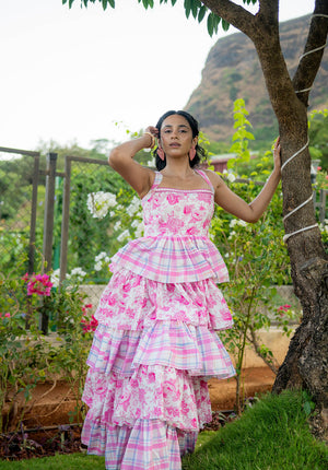 Full-pose of model in a sleeveless floral dress, standing in a garden setting