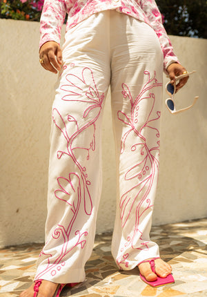 Solid white pants featuring pink embroidery, styled as part of a co-ord set