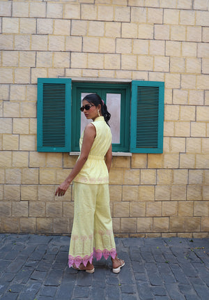 Side view of pastel yellow coord set with palm embroidery and pink lace hem detailing