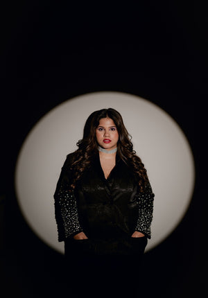 Model showcasing the front silhouette of the Blackout Blazer in a spotlight setting.