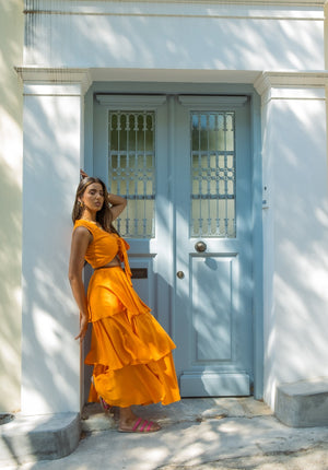 Bright flowy tiered ruffle skirt in a bold orange hue, perfect for summer vacations, resort wear, and stylish brunch looks – Ur•Mish