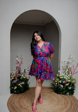 Model wearing the Back from Vacay Dress – floral-printed cotton summer dress with a ruffle hem and notch collar