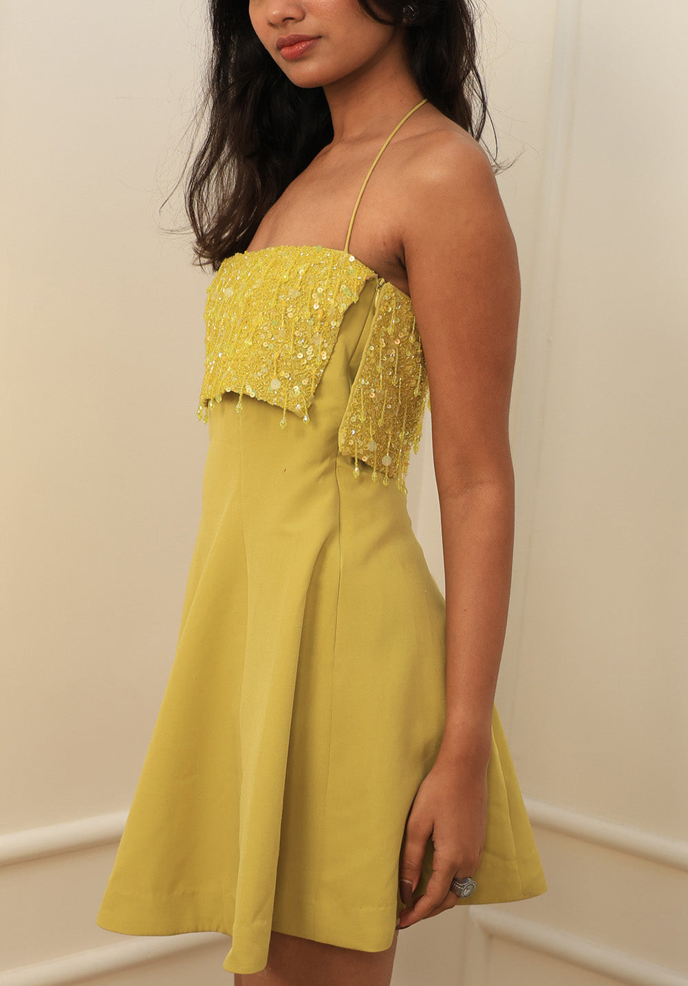 Side view of the Limoncello Sequin Halter Mini Dress featuring sequin overlay and fitted waist.