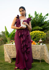 Model wearing a full-length ruffle dress, holding a rabbit in a soft outdoor setting