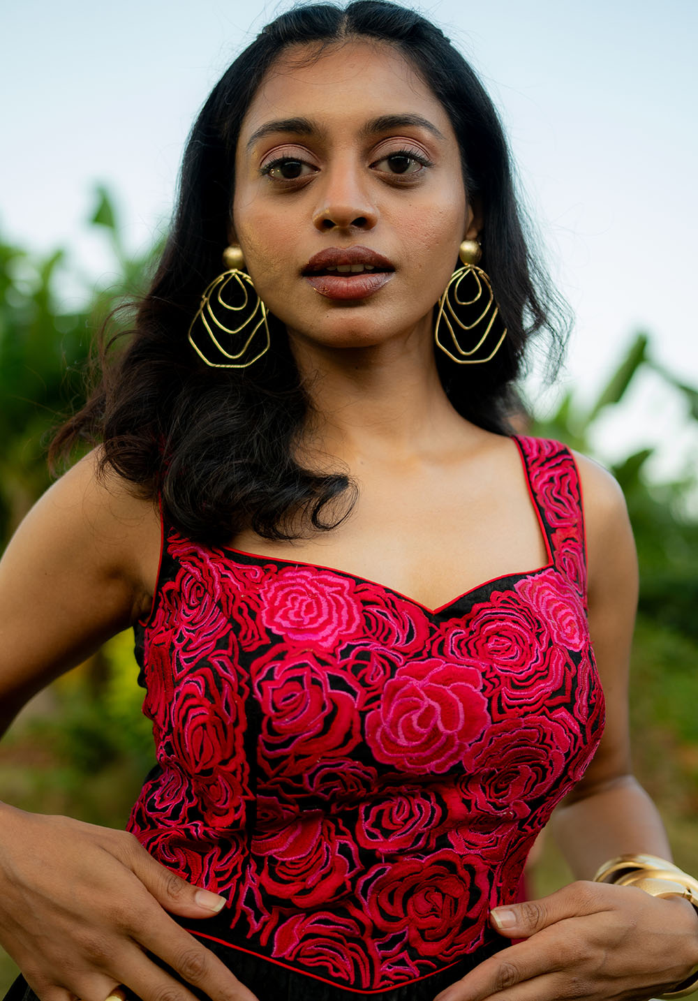 Close-up of model wearing a rose-embroidered bustier dress in black and red, highlighting the embroidery details.