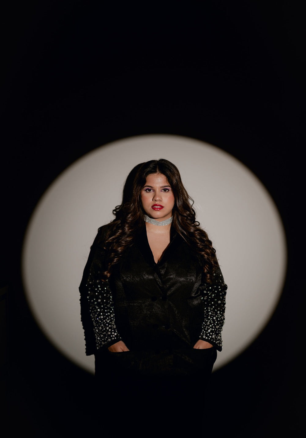 Model showcasing the front silhouette of the Blackout Blazer in a spotlight setting.